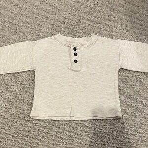 Cozy Cream Long Sleeve Kids Tee with a button neck on the front